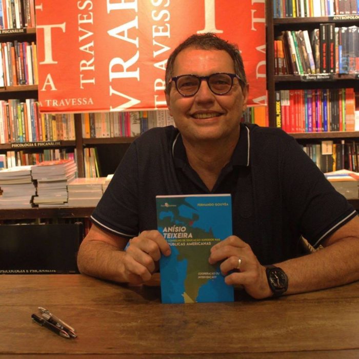 Professor Fernando Gouvêa segurando seu livro sobre Anísio Teixeira durante o lançamento
